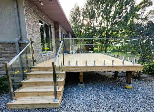 Beautiful Cedar deck with glass railings by Creative Decks Niagara